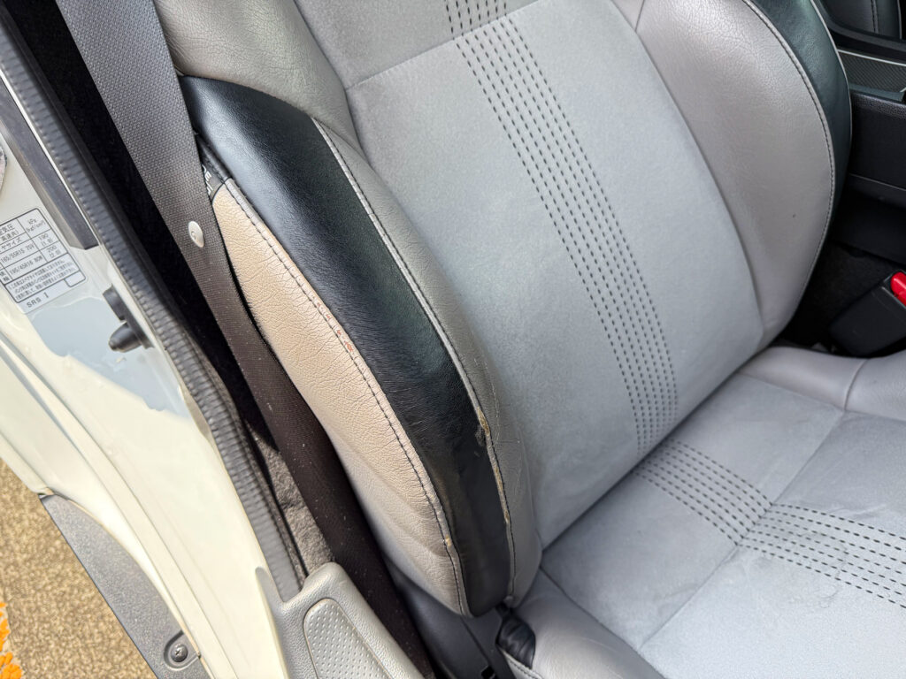 運転席シートの本革が一部破れています。