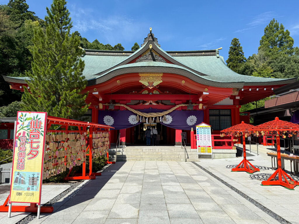 宮城縣護國神社の赤い社殿と境内の風景。七夕の飾りや絵馬が見られる。