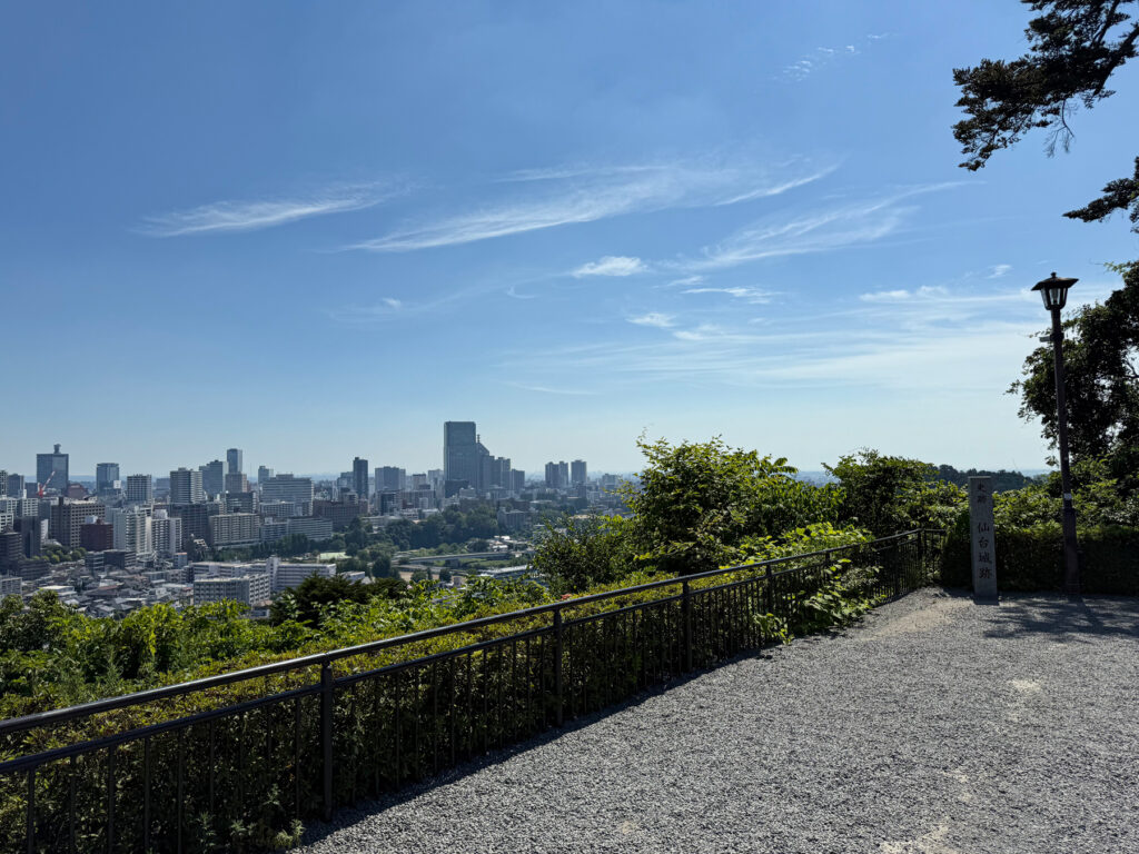 仙台市街を見渡せる青葉山公園の展望スポット。晴れた青空と緑の草木が広がる風景が印象的。