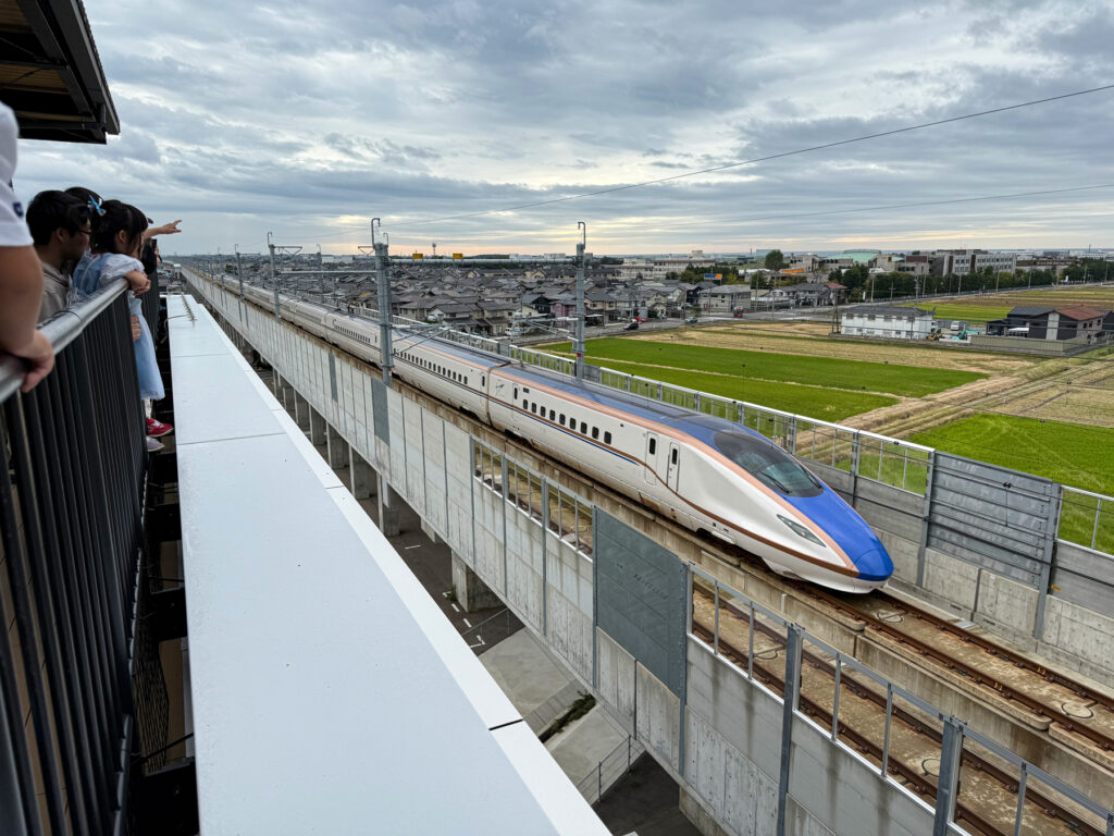 隣接する線路を走行するW7系新幹線