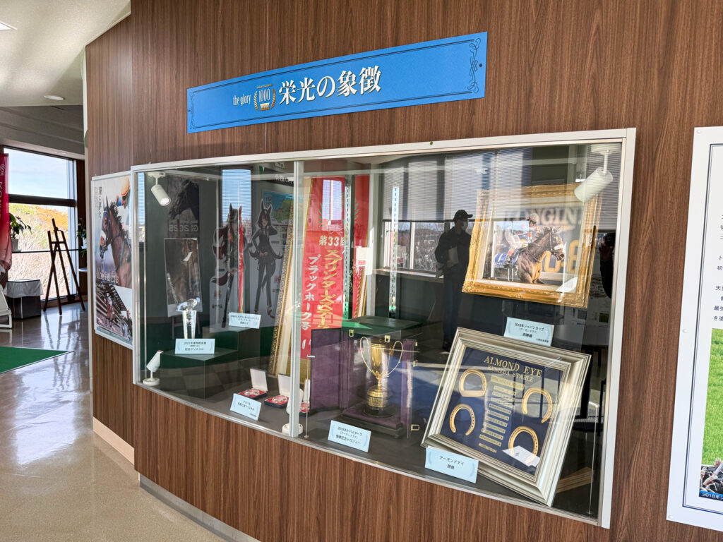 アーモンドアイの蹄鉄やブラックホークのスプリンターズSの優勝レイなど
国枝調教師の功績を讃える展示コーナー