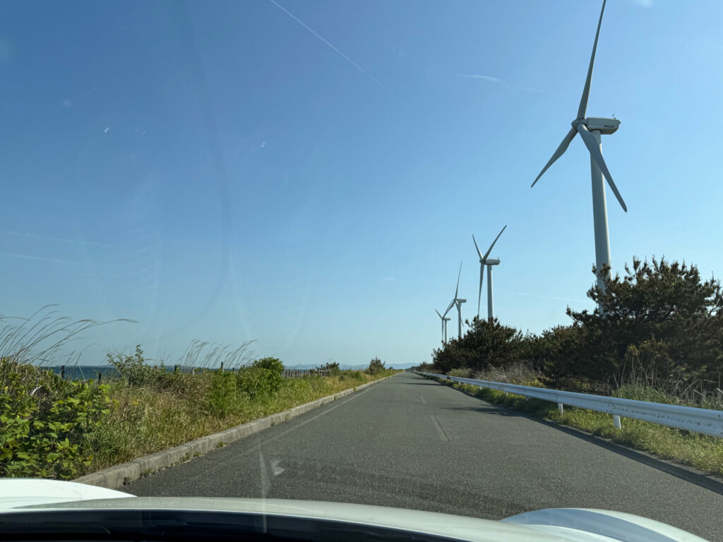 風車が立ち並ぶ海沿いの長い直線道路