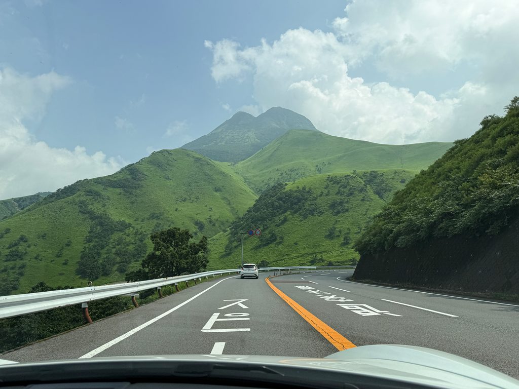 どこまでも続く緑の山々と、そこを縫うように伸びるオレンジのセンターライン